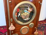 a wooden clock on a rug on the floor