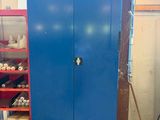 une armoire bleue dans un garage, avec des outils sur les étagères