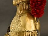 a gold helmet with a red flower on it