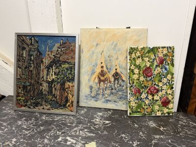 trois tableaux posés par terre les uns à côté des autres