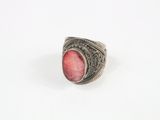 un gros plan d'une bague en argent sertie d'une pierre rouge