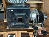 un vieil appareil photo posé sur une table à côté d'une boîte en bois