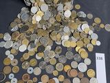 coins spilling out of a metal container on a table next to a ruler