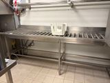 a large stainless steel counter with a sink and a kettle on it