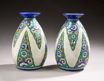 une paire de vases bleus et blancs posés sur une table blanche