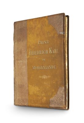 un vieux livre à la couverture brune posé sur une surface blanche