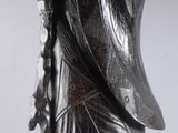 statue représentant un homme tenant un bâton et un bâton à la main