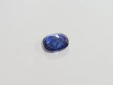 a blue sapphire stone on a white surface