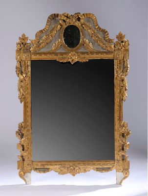 un miroir avec un cadre doré et une horloge dessus