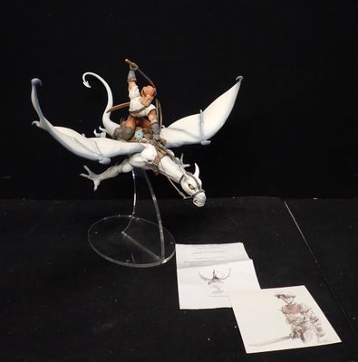 une figurine représentant un homme chevauchant un dragon, posée sur une table