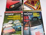 three magazines on a table with a car in the background