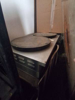 un moule à pizza posé sur une cuisinière dans une cuisine