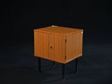 une image représentant une petite armoire en bois sur fond noir
