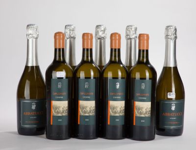 six bottles of wine are lined up in a row on a white surface