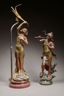 deux statues en bronze représentant une femme et un homme avec un oiseau sur la tête