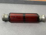 une bouteille en verre rouge munie d'un bouchon en métal