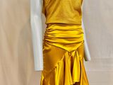 Le mannequin porte une robe jaune à volants.
