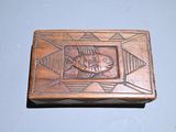 a wooden box with a fish on it on a table