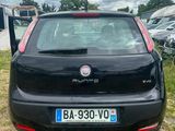 the back of a small black car parked in a field