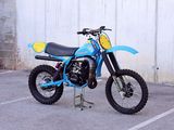 a blue dirt bike parked in a parking lot