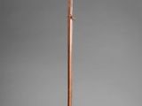 a large wooden stick with a long handle on a gray background