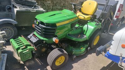 une tondeuse à gazon verte garée sur un parking