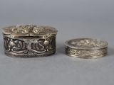 a close up of a silver box and a coin on a table
