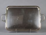 an antique silver plate with handles and handles on a stand