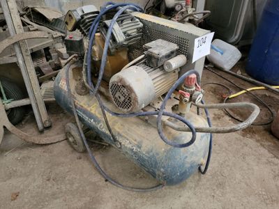 an air compressor sitting on top of a pile of junk