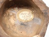 a close up of a small vase with a coin in it