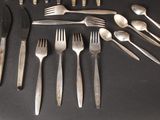 a lot of silverware on a table with forks and spoons