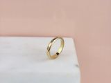 une bague en or posée sur un bloc de marbre
