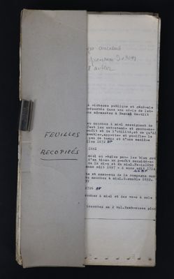 un livre ouvert posé sur une table à côté d'une table noire