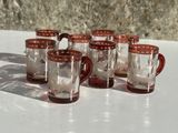 six tasses rouges et blanches posées sur une table blanche