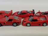 five red cars lined up in a row on a white surface