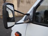 a side view mirror of a white truck with a black handle