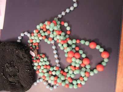 un sac à main et un collier de perles posés sur une table