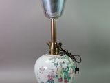 a white vase that has a metal bell on it