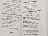 an open book with black writing on it sitting on top of a table