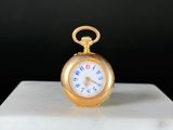 une montre de poche en or posée sur un bloc de marbre