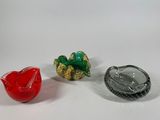 three small glass objects sitting on a white surface