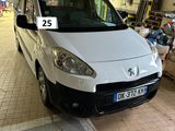 une camionnette blanche garée dans un garage, avec une plaque d'immatriculation