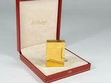 an image of a gold lighter in a red box on a white surface