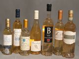 Des bouteilles de vin sont alignées sur une table devant un fond gris.