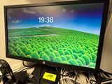 un écran d'ordinateur posé sur un bureau, à côté d'un clavier et d'une souris