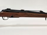 gros plan d'un fusil posé sur un support sur une surface blanche