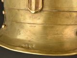 a close up of a gold helmet on a black background