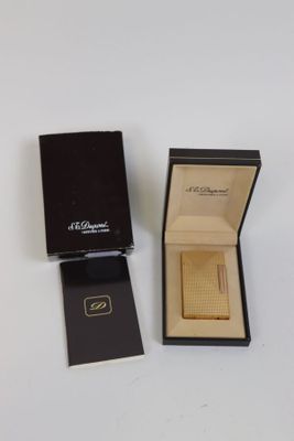 une boîte ouverte contenant une montre, posée sur une surface blanche