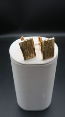 gold square stud earrings on a white box with a black background