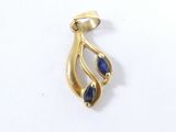 un gros plan d'un pendentif en or orné de pierres bleues sur un fond blanc